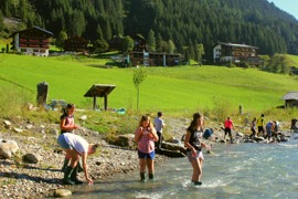 Kinder forschen am Fluss, in der Bildmitte das Haus des Wassers