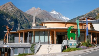 Am Bild ist das barrierefreie Haus der Steinböcke in Heiligenblut mit dem Großglockner im Hintergrund