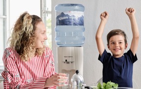 Alpenwasser Mutter mit Kind und Wasserspender