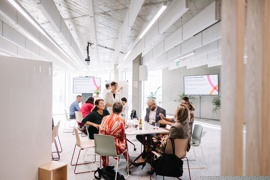 Offener Raum mit zwei Sitzgruppen mit Tischen, Whiteboards und Bildschirmen. Offener Raum mit zwei Sitzgruppen mit Tischen, Whiteboards und Bildschirmen.