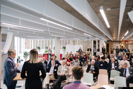 Blick auf das Publikum eines Events, mit Speakern (rückseitig) im Vordergrund und moderner Lounge im Hintergrund. Blick auf das Publikum eines Events, mit Speakern (rückseitig) im Vordergrund und moderner Lounge im Hintergrund.