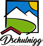 Logo Haus Dschulnigg - Haus mit schneebedeckten Bergen im Hintergrund