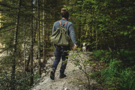 Ein Mann spaziert durch den Wald am Weg zum Umweltzeichen