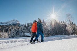 Zwei Winterwanderer in der Blaa Alm inmitten verschneiter Winterlandschaft. 