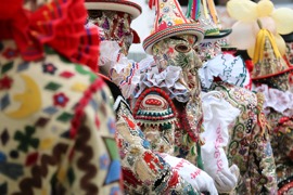 Ein Flinserl im Ausseer Fasching steht im Mittelpunkt, umgeben von anderen Flinserln. Die Szene zeigt eine traditionelle Faschingsdarstellung, Teil des immateriellen UNESCO-Weltkulturerbes