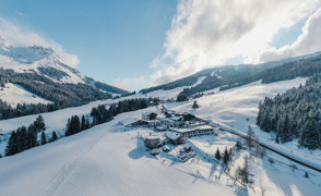 Vogelperspektive auf das &Uuml;bergossene Alm Resort, eingebettet in winterliche Landschaft