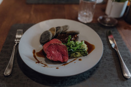 Sch&ouml;n angerichtete Speise mit Fleisch und Gem&uuml;se auf einem Teller.