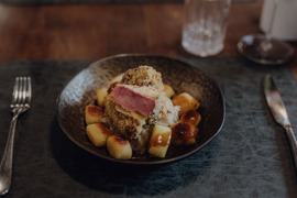Sch&ouml;n angerichtete Speise mit Fleisch und Gem&uuml;se auf einem Teller.