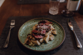 Sch&ouml;n angerichtete Speise mit Fleisch und Gem&uuml;se auf einem Teller.