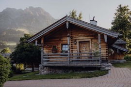 Chalet im Sommer, umgeben von gr&uuml;nen Wiesen.
