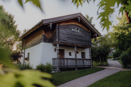 Chalet im Sommer, umgeben von gr&uuml;nen Wiesen.