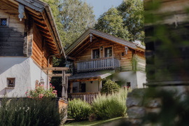 Chalet im Sommer, umgeben von gr&uuml;nen Wiesen.