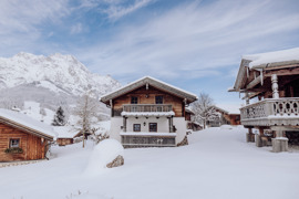 Chalet im Winter, umgeben von wei&szlig;er Schneelandschaft.