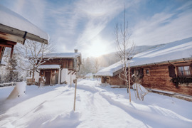 Chalet im Winter, umgeben von wei&szlig;er Schneelandschaft.