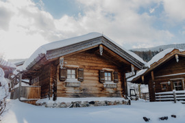 Chalet im Winter, umgeben von wei&szlig;er Schneelandschaft.