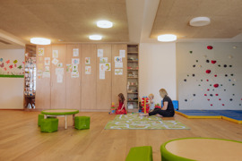 Frau und zwei kleine Kinder spielen im Indoorspielraum des Hotels.