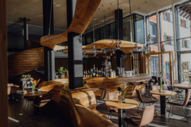 Bar Freiraum mit geschwungener Holztheke im Naturresort Puradies.