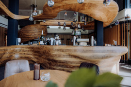 Geschwungene Holztheke der Bar Freiraum im Naturresort Puradies.