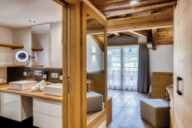 Badezimmer mit Doppelwaschbecken und Blick ins Zimmer der Suite im Naturresort Puradies.