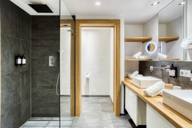 Badezimmer mit Regendusche und Doppelwaschbecken in der Suite im Naturresort Puradies.