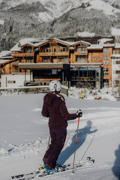Person auf Skiern auf der hauseigenen Piste vor dem Naturresort Puradies im Winter.