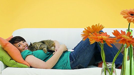 Frau mit Katze auf weißen Sofa liegend