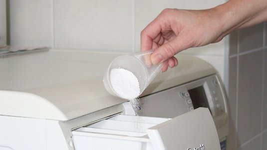 Waschmaschine wird mit Dosierer befüllt