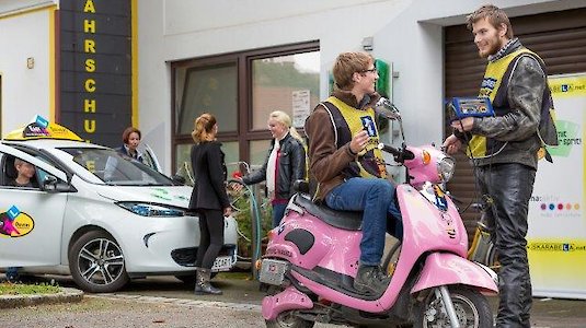 Fahrschüler und -lehrer reden vor der Fahrschule