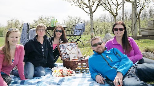 Bloggerinnen und Blogger gemeinsam mit Kräuterpädagogin Resi Kroiss beim Picknick im Erlebnisobstgarten der Vita Vita Pannonia