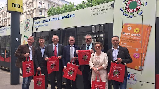 Österreichische Mensen vor Umweltzeichen-Straßenbahn