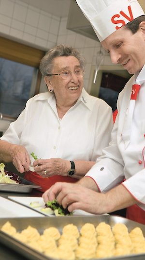 Koch und Bewohnerin beim gemeinsamen Kochen