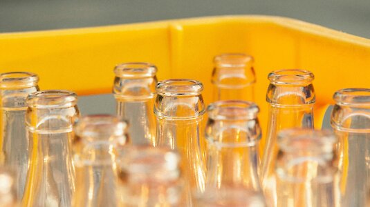 Leere Glasflaschen in gelber Kiste