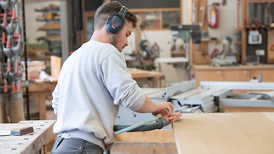 Tischler schleift Holzplatte