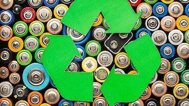 Alte Batterien hinter einem Recycling-Zeichen